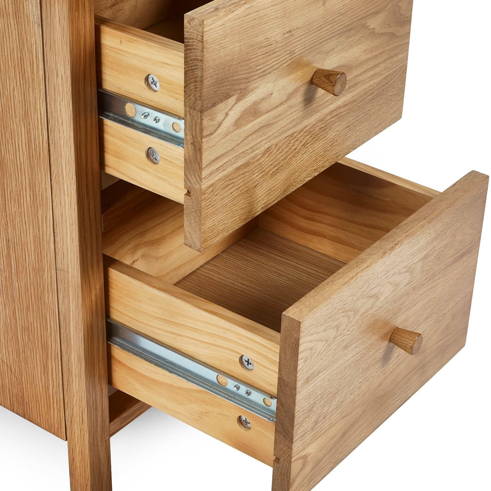 oak chest of drawers with metal runners and wooden handles, two drawers open, close-up view