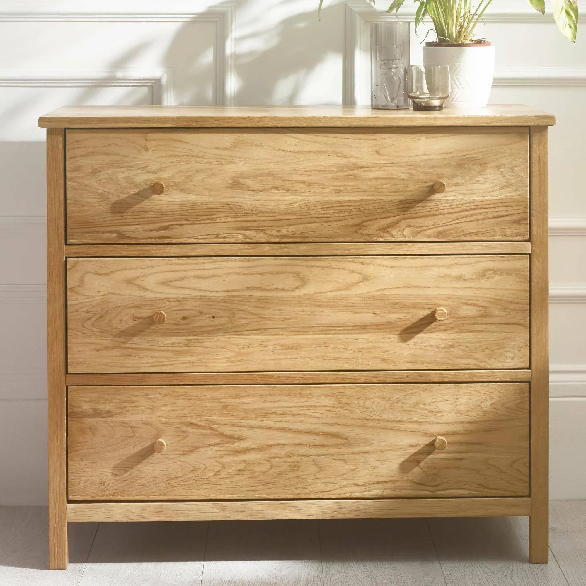 Oak wood chest of drawers with three drawers, round knobs, and natural finish