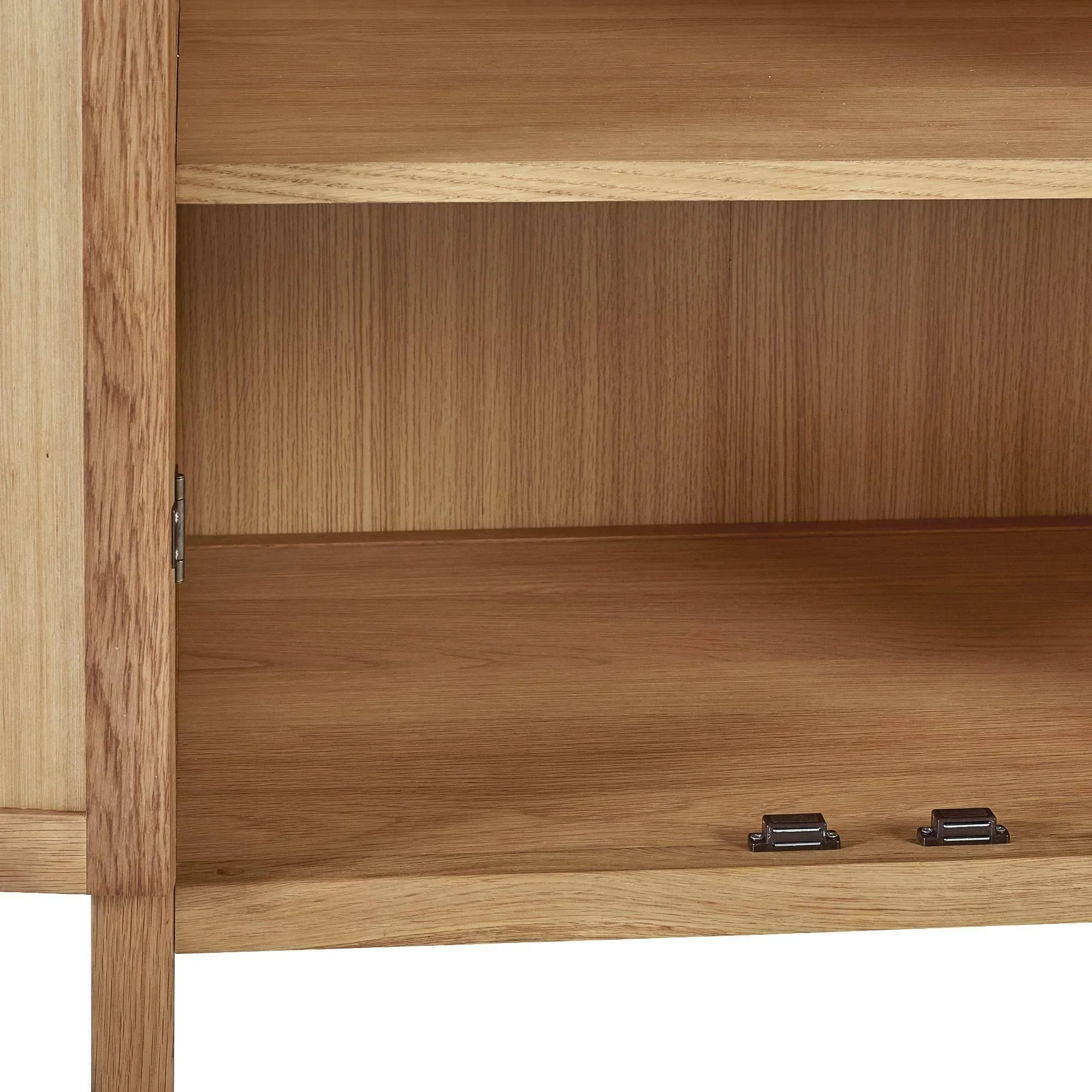 Interior shelves of oak sideboard with open door and metal hinges