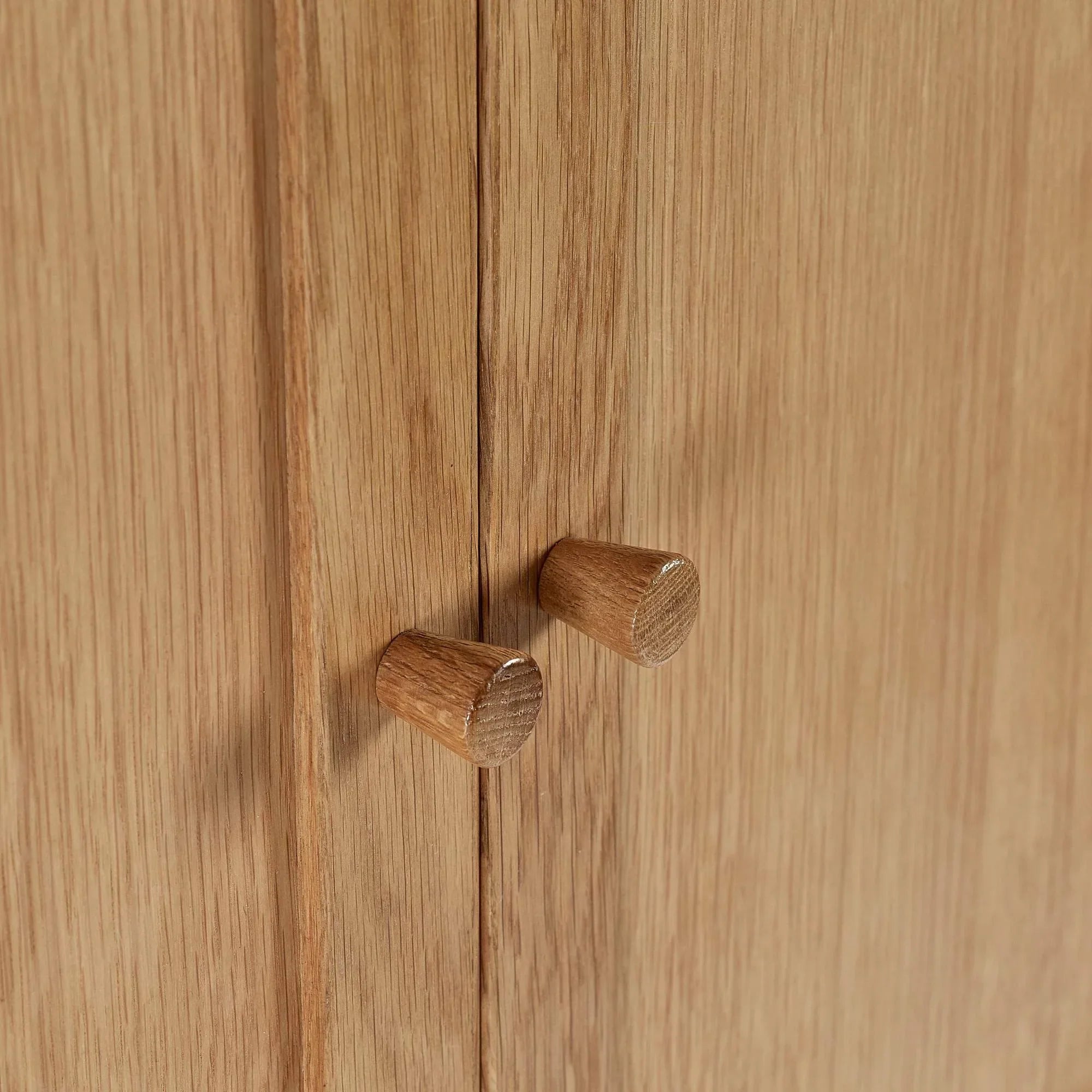 Closeup of oak cabinet doors with round wooden handles