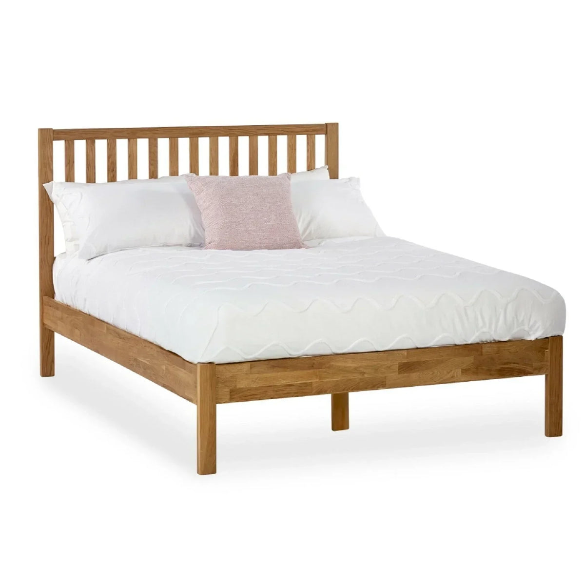 Oak wooden bed frame with slatted headboard, white bedding and pink accent cushion