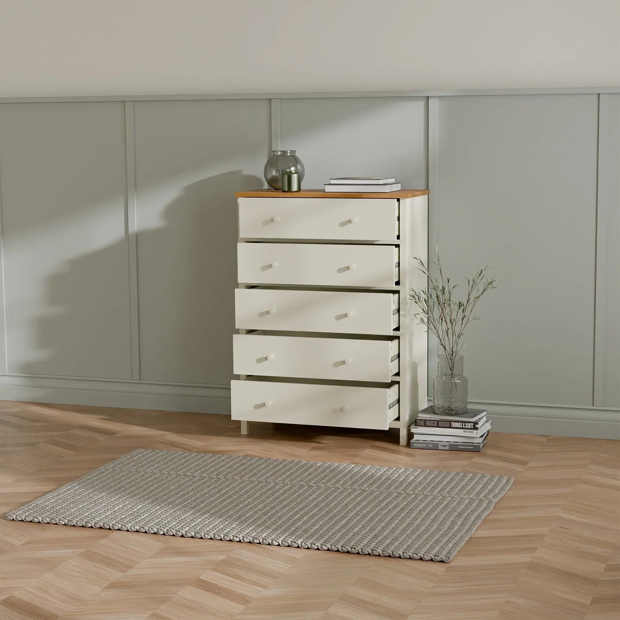 Ivory and oak wide chest of drawers with all drawers open in a modern bedroom setting