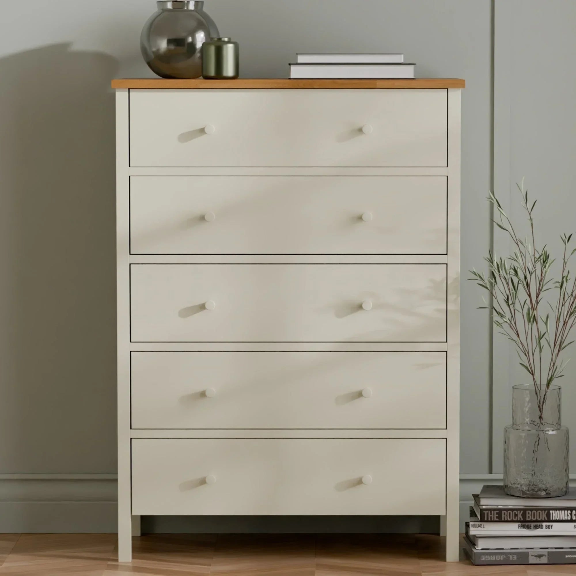 Cream chest of drawers with wooden top, styled with vases, books and plant decor