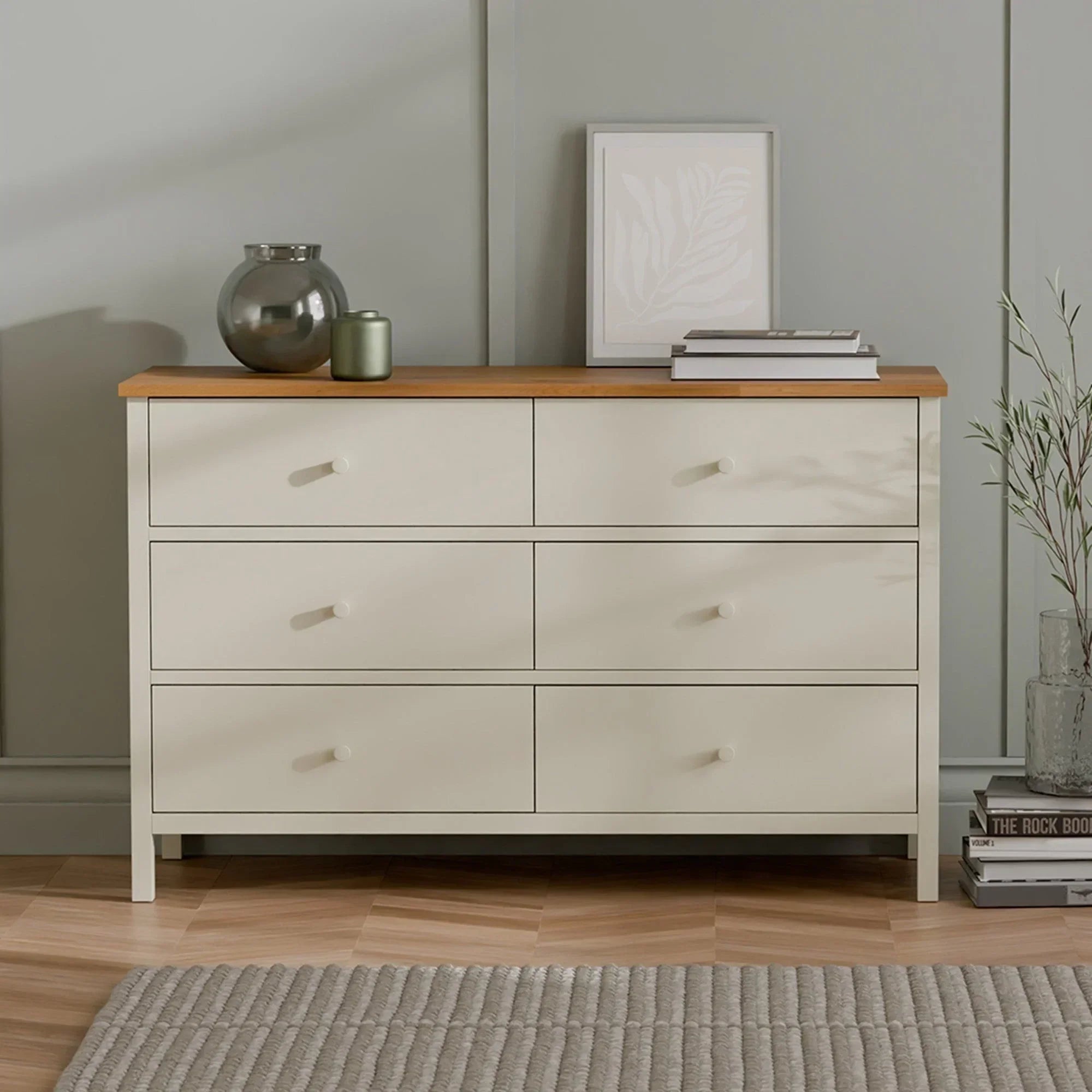 Cream six drawer chest with wooden top, modern handles, decor and books on top