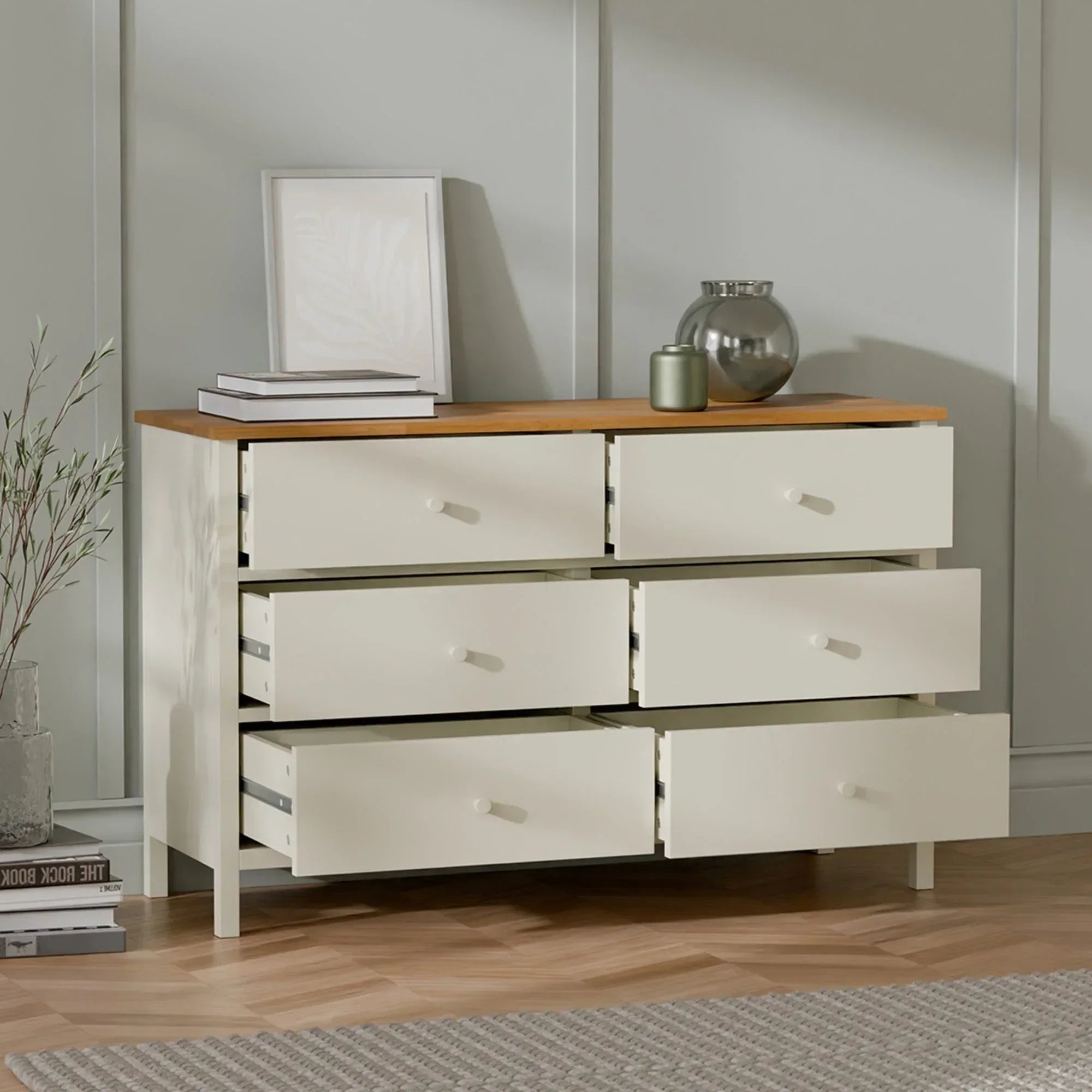 Cream chest of drawers with wooden top and six drawers, styled in a modern living room