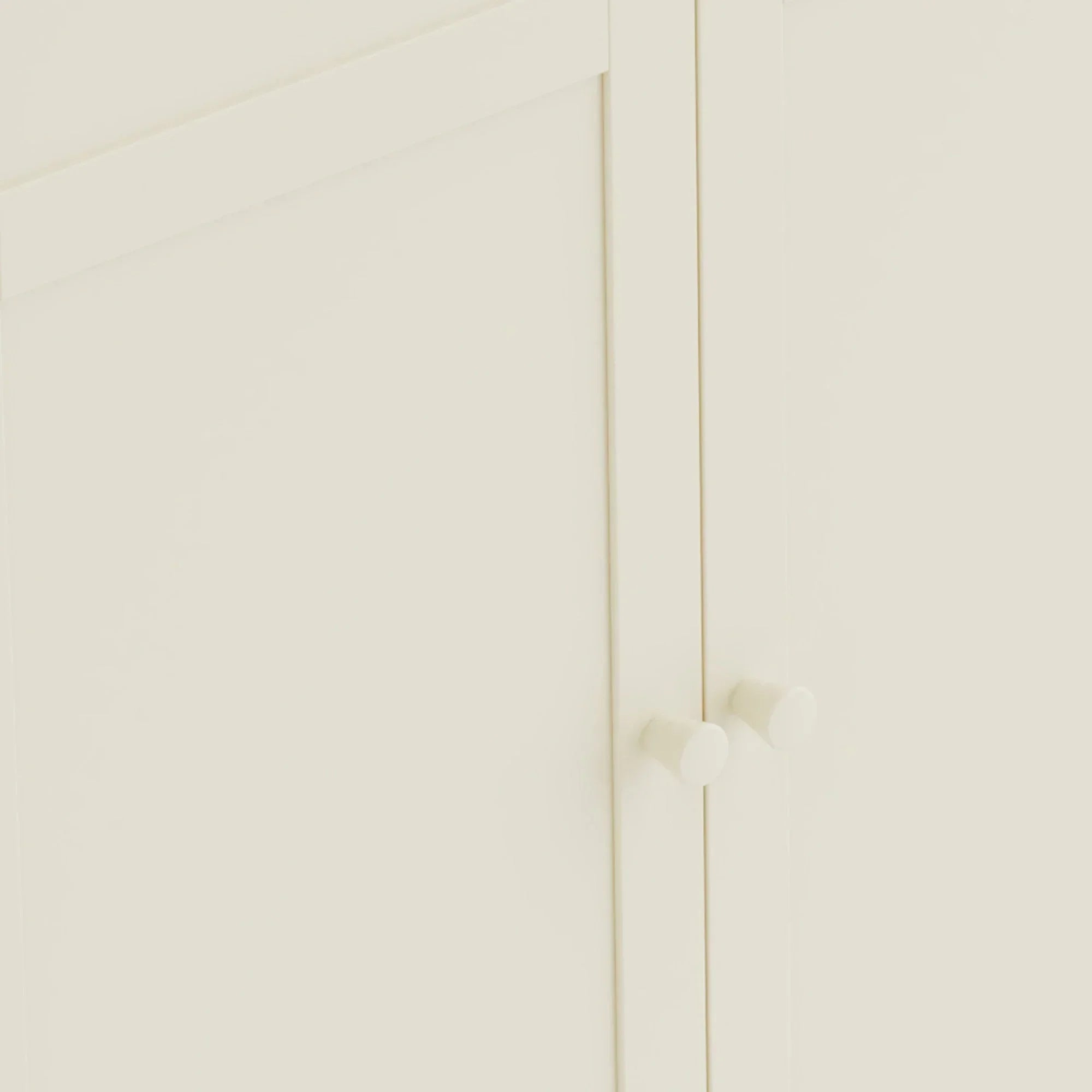 Close-up of cream wooden cabinet doors with round handles
