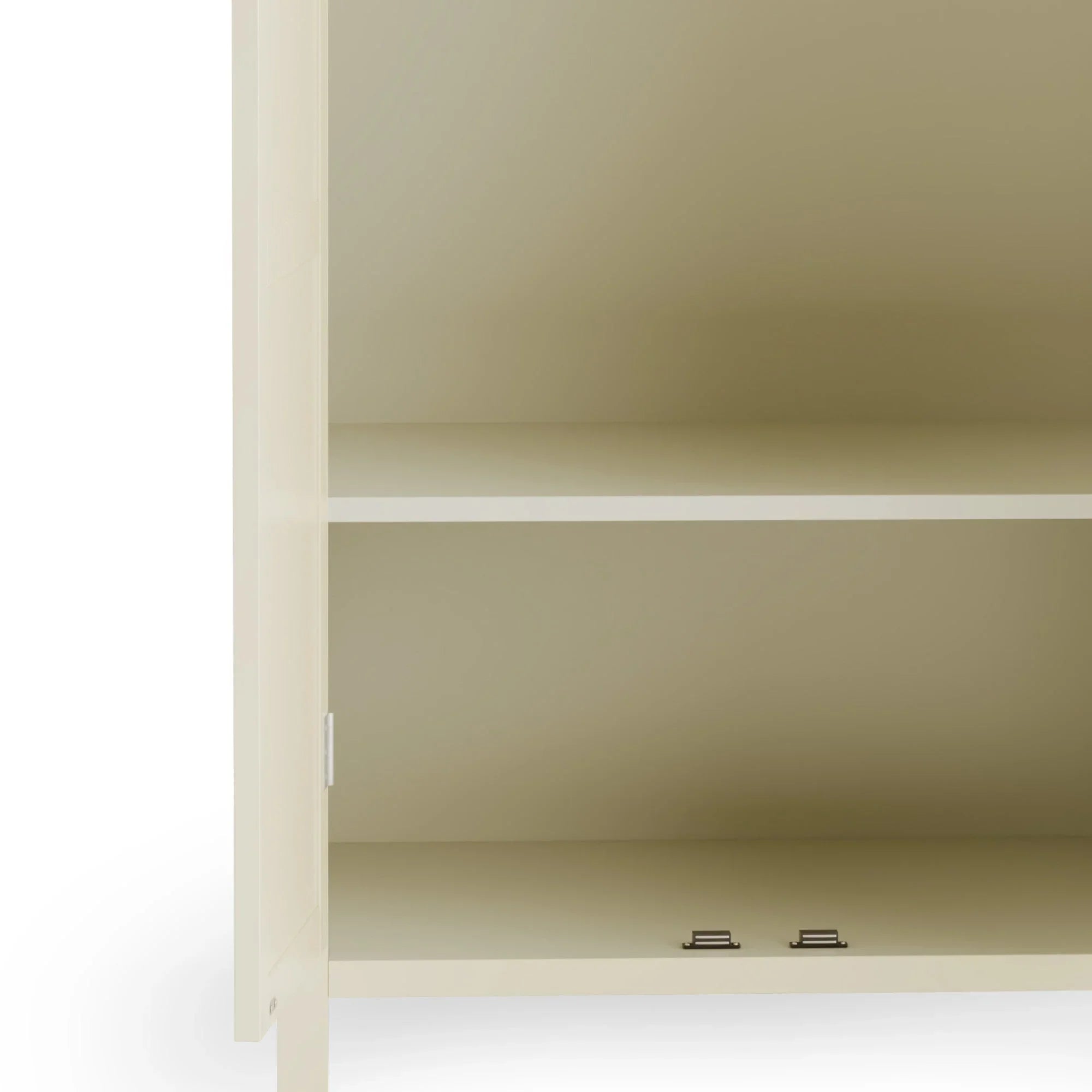 Cream storage cabinet interior with single shelf and metal hinges visible at the base