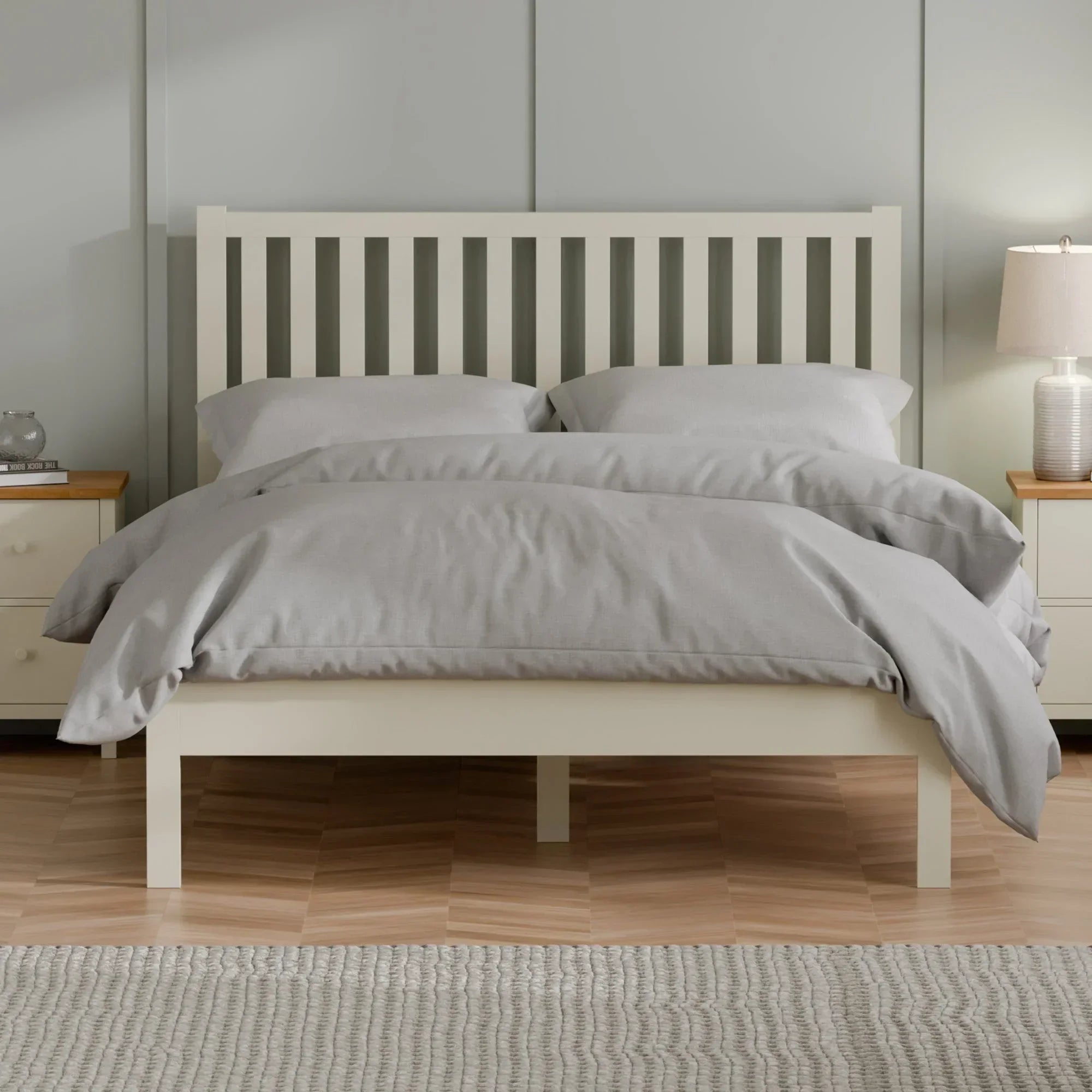 Cream wooden bed frame with slatted headboard and grey bedding in a modern bedroom