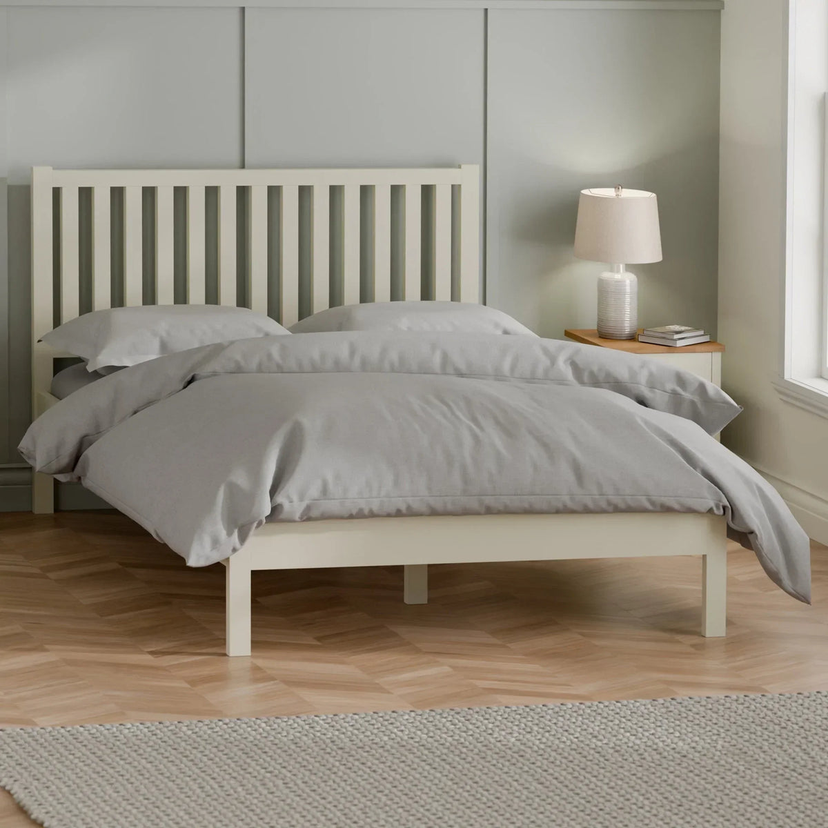 Cream wooden bed frame with slatted headboard and grey bedding in modern bedroom