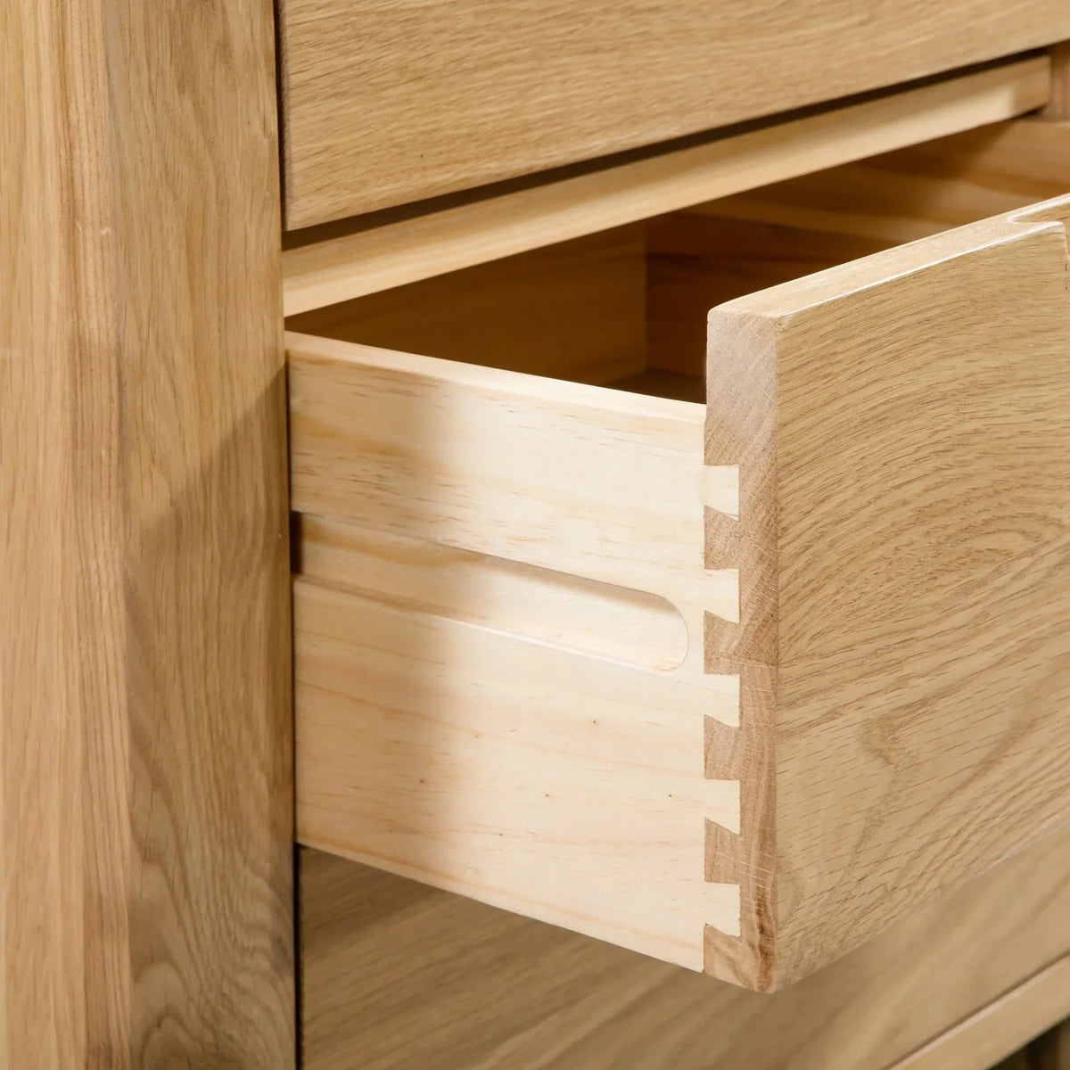 Oak bedside table with open dovetail drawer showing wood grain detail