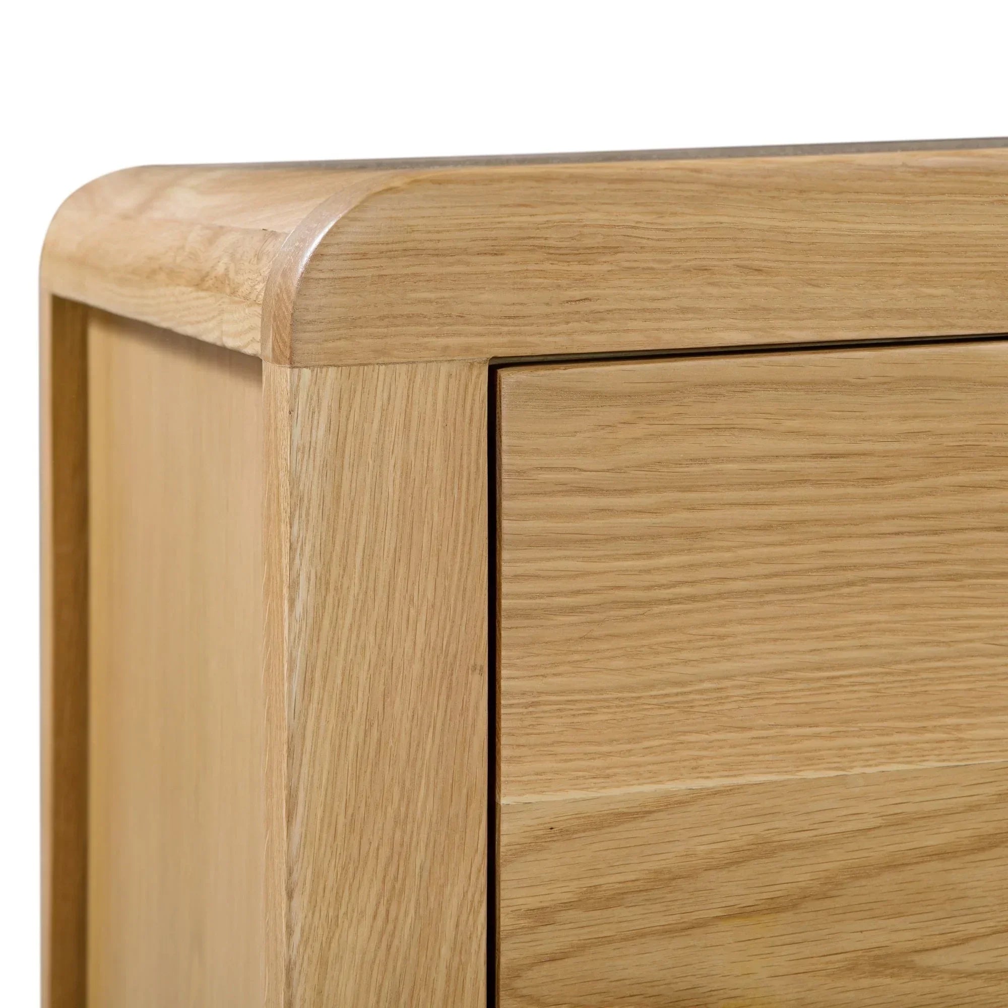 Close-up of oak 6 drawer wide chest with curved corner and wood grain detail