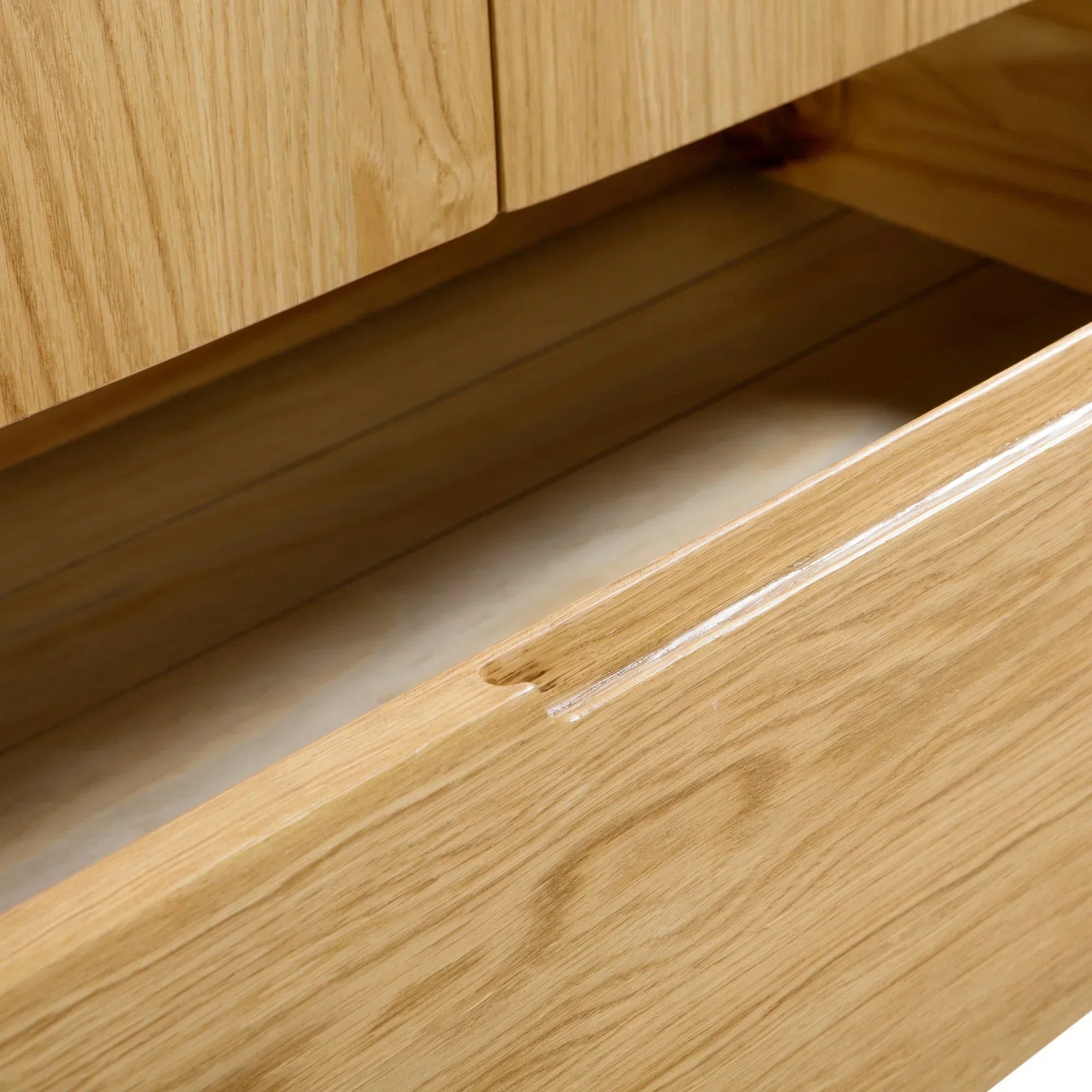 Closeup of oak wardrobe drawer with finger pull handle and wood grain detail