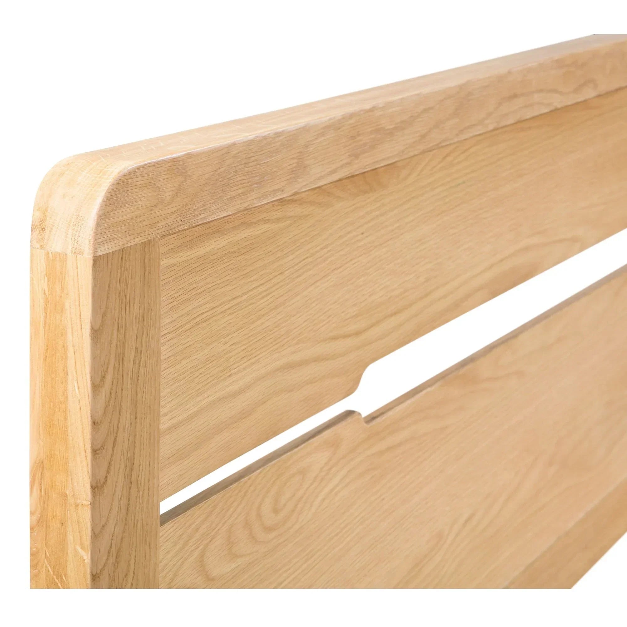 Closeup of oak king bed headboard with curved edges and natural wood grain detail