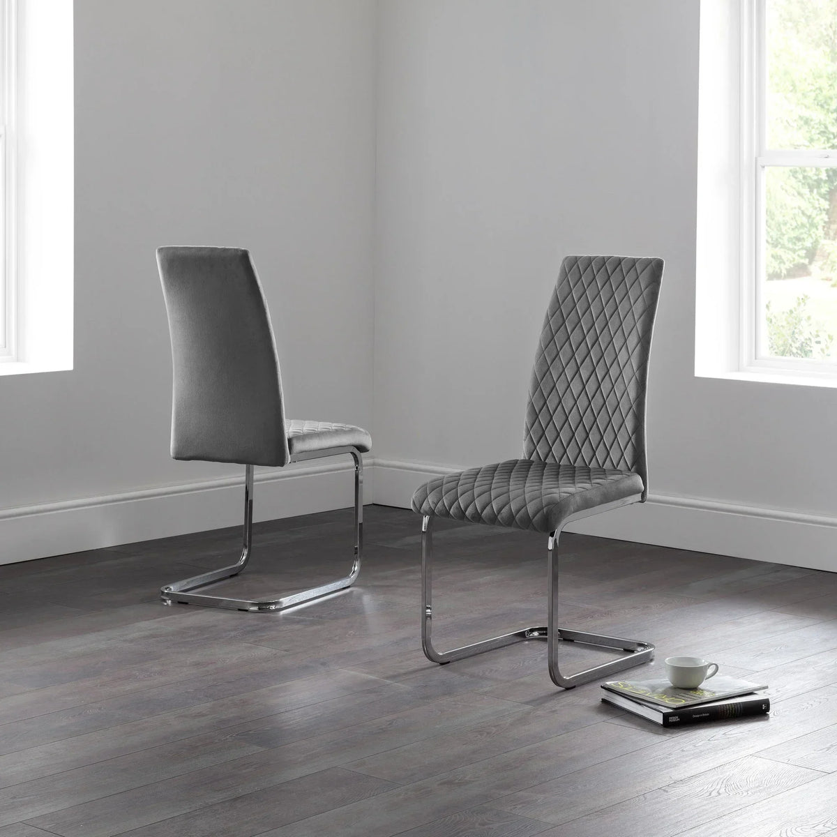 Grey velvet cantilever dining chairs with quilted seat designs on dark wood floor