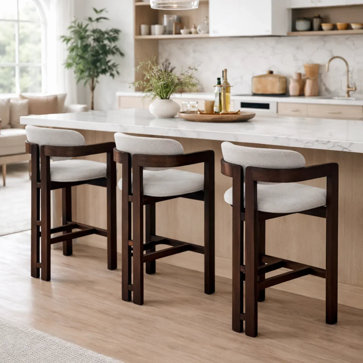 Clara barstool with dark wood frame and light upholstery at modern kitchen island