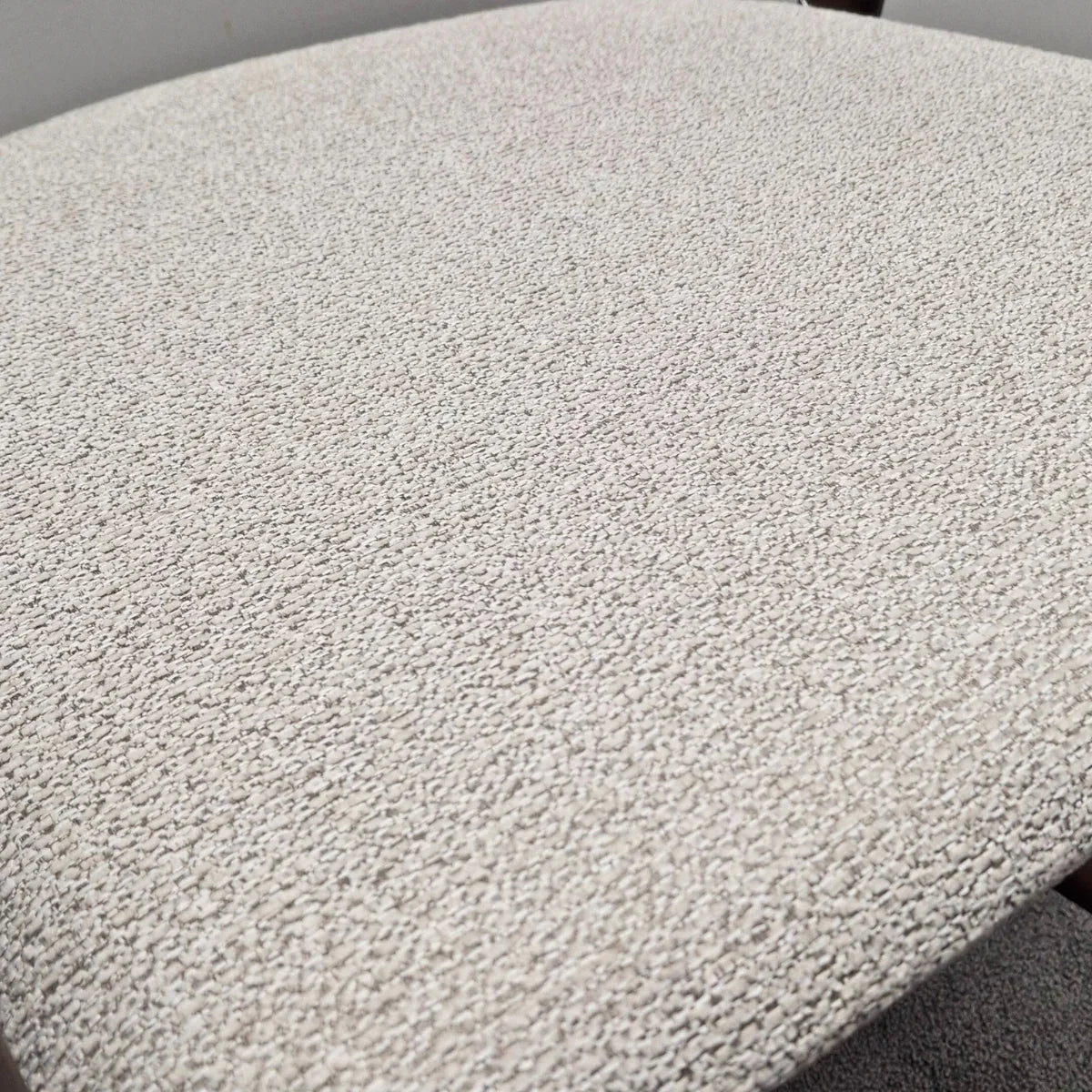 Closeup of Clara barstool upholstered seat in textured beige fabric