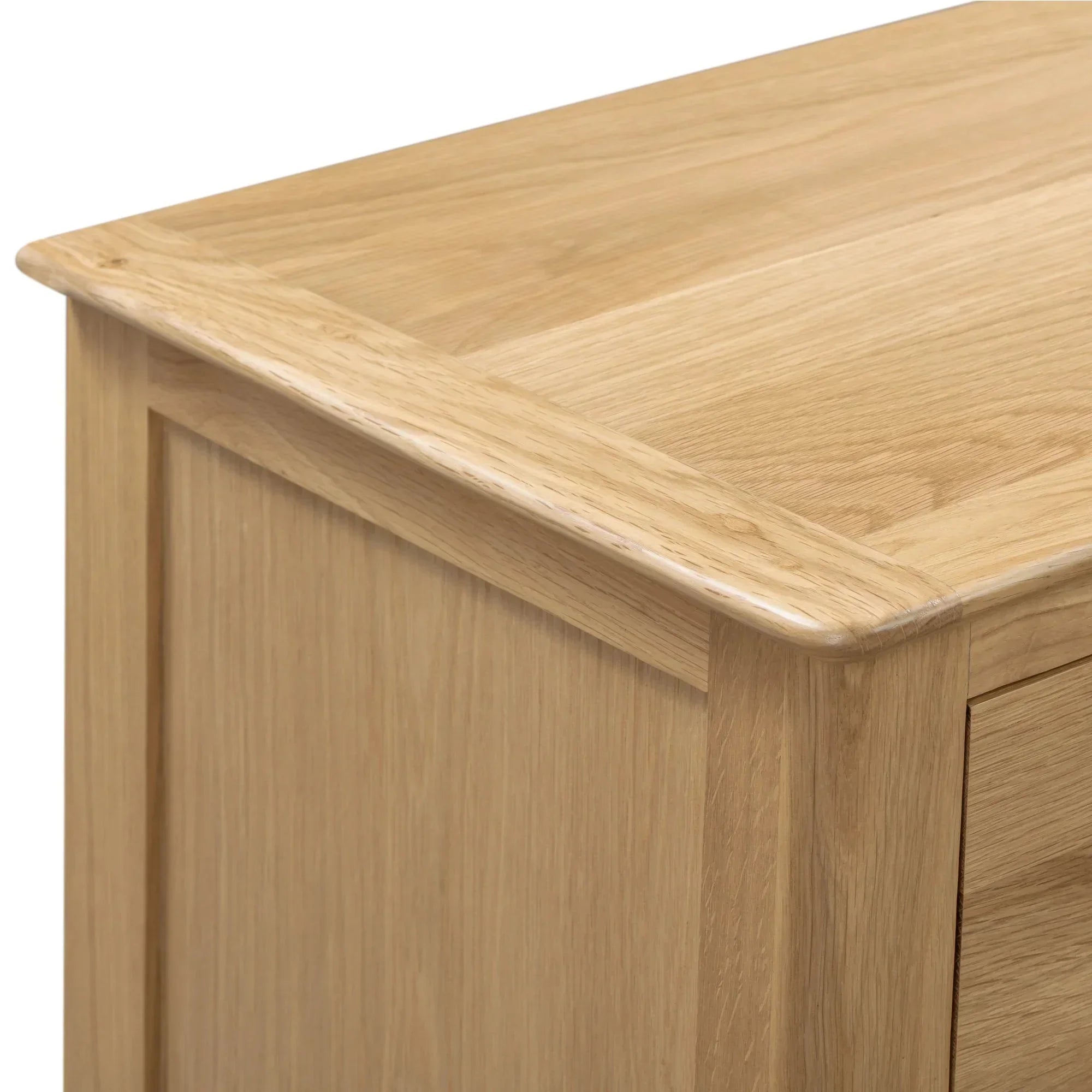 Oak finish detail on corner of wide chest of drawers, highlighting wood grain and craftsmanship