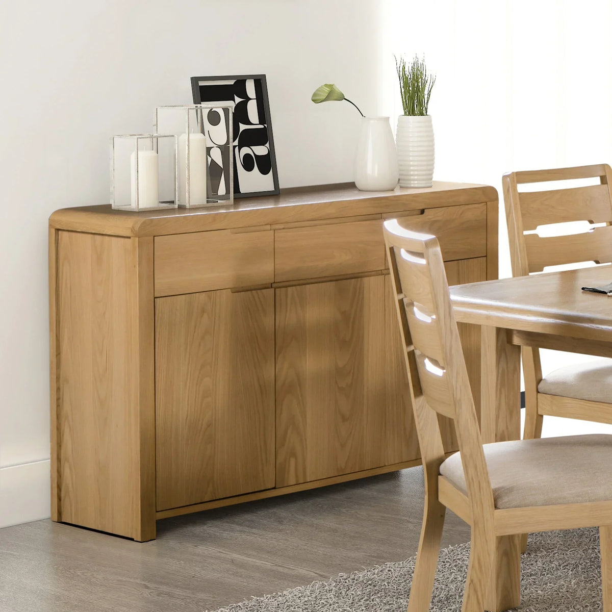 Oak sideboard with three drawers and decor accents in modern dining room setting