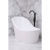 White freestanding bathtub with a black faucet against a marble wall.