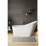 Modern bathroom with a freestanding white bathtub against a dark gray wall.