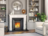 Modern living room with cream armchair, built-in shelves, and lit fireplace
