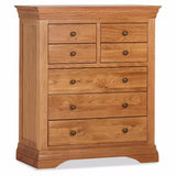 Oak 7 drawer chest with brass knobs and paneled sides, classic bedroom storage furniture