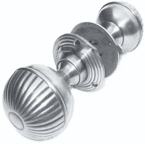 Brushed metal door knob with fluted round design, shown at an angle
