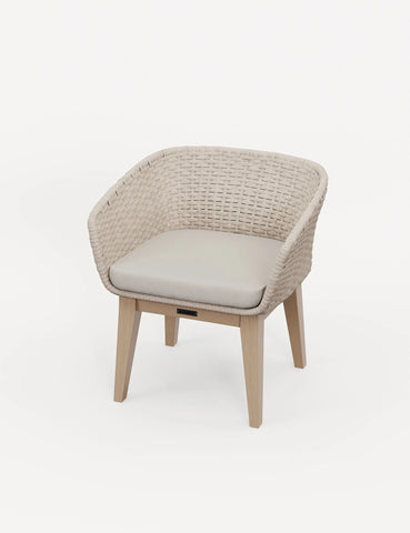 Beige rattan accent chair with light wood legs and cushioned seat on white background