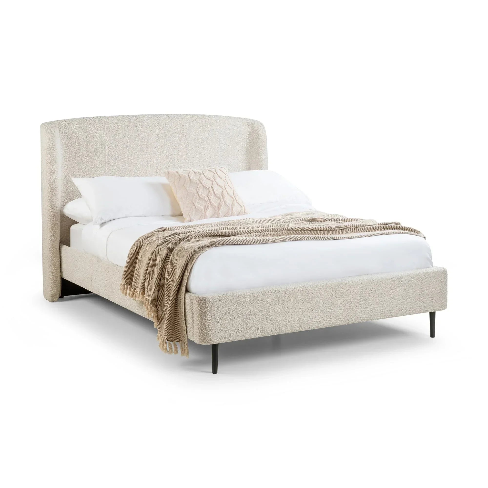 Ivory boucle double bed with upholstered headboard, white bedding, and beige throw blanket