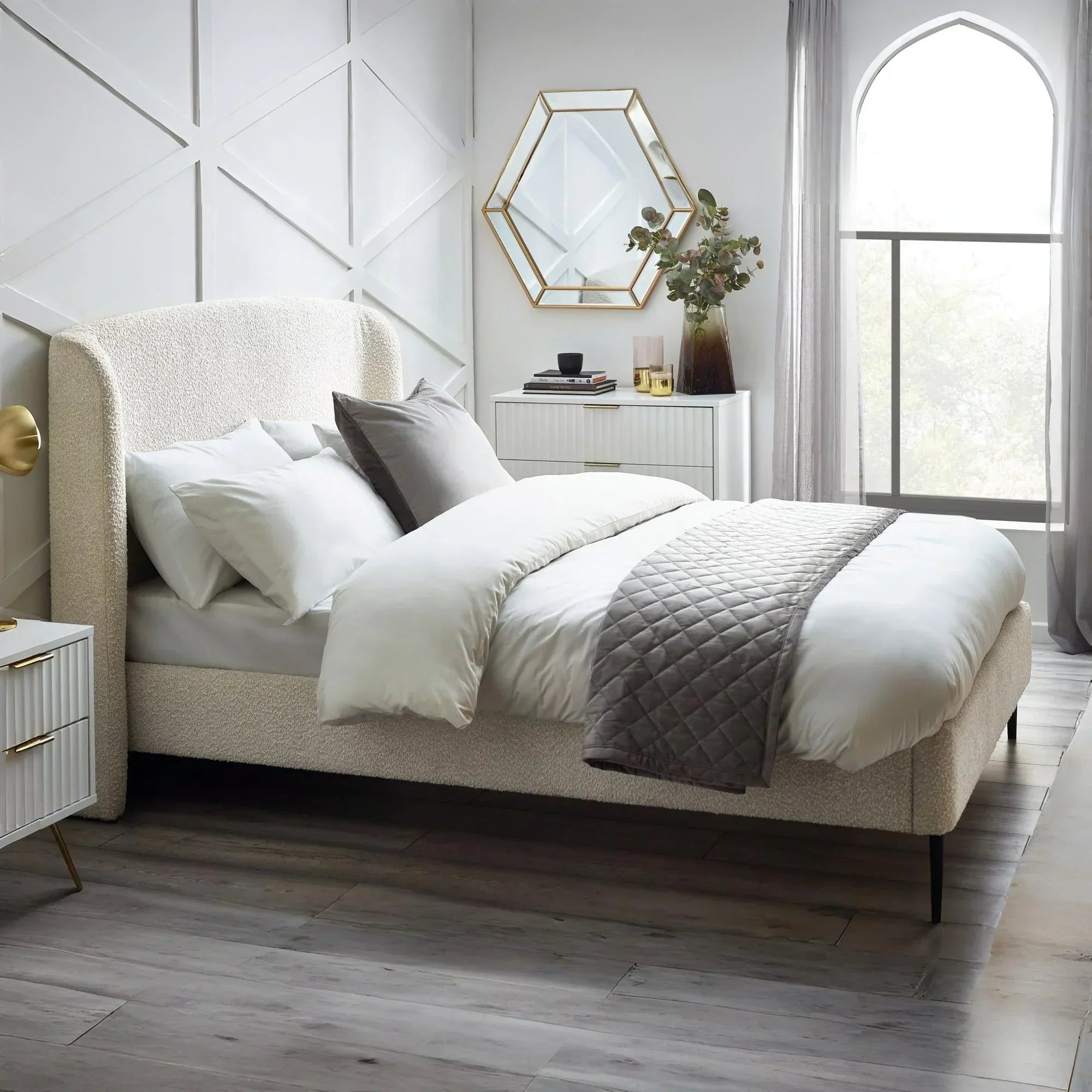 Ivory boucle double bed with upholstered headboard in modern bedroom with white bedding
