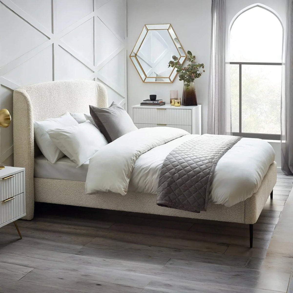 Ivory boucle double bed with upholstered headboard in modern bedroom with white bedding