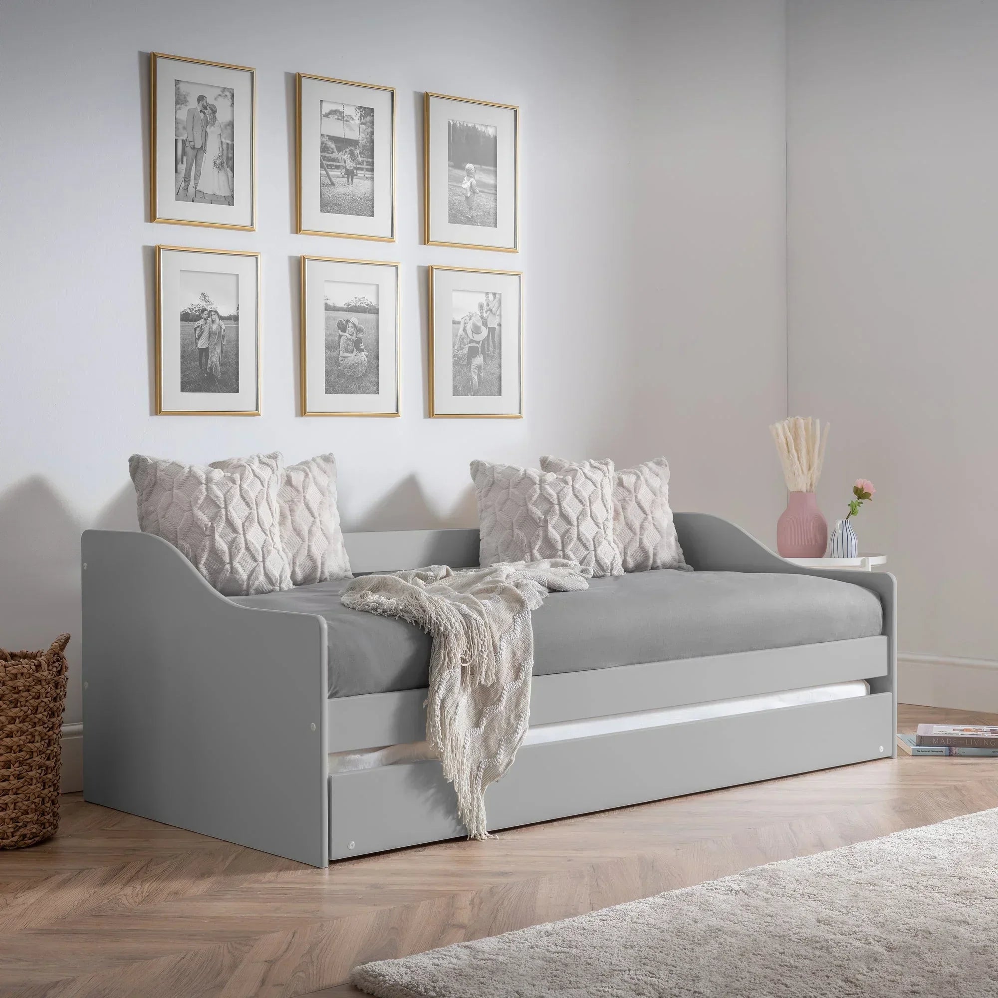 Dove grey single daybed with trundle, plush cushions, and soft throw in modern room