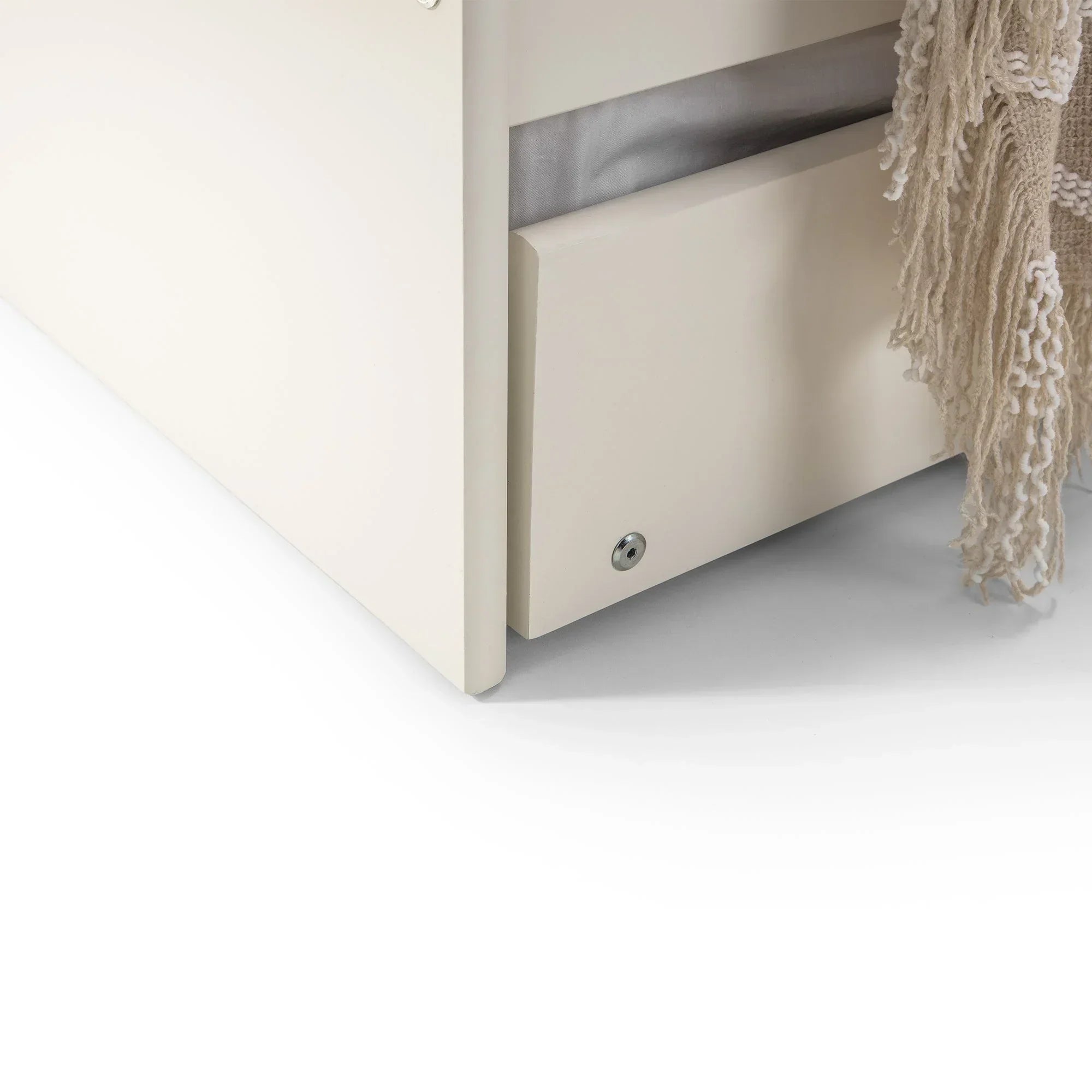 Surf white single daybed corner with visible underbed storage drawer and hanging throw