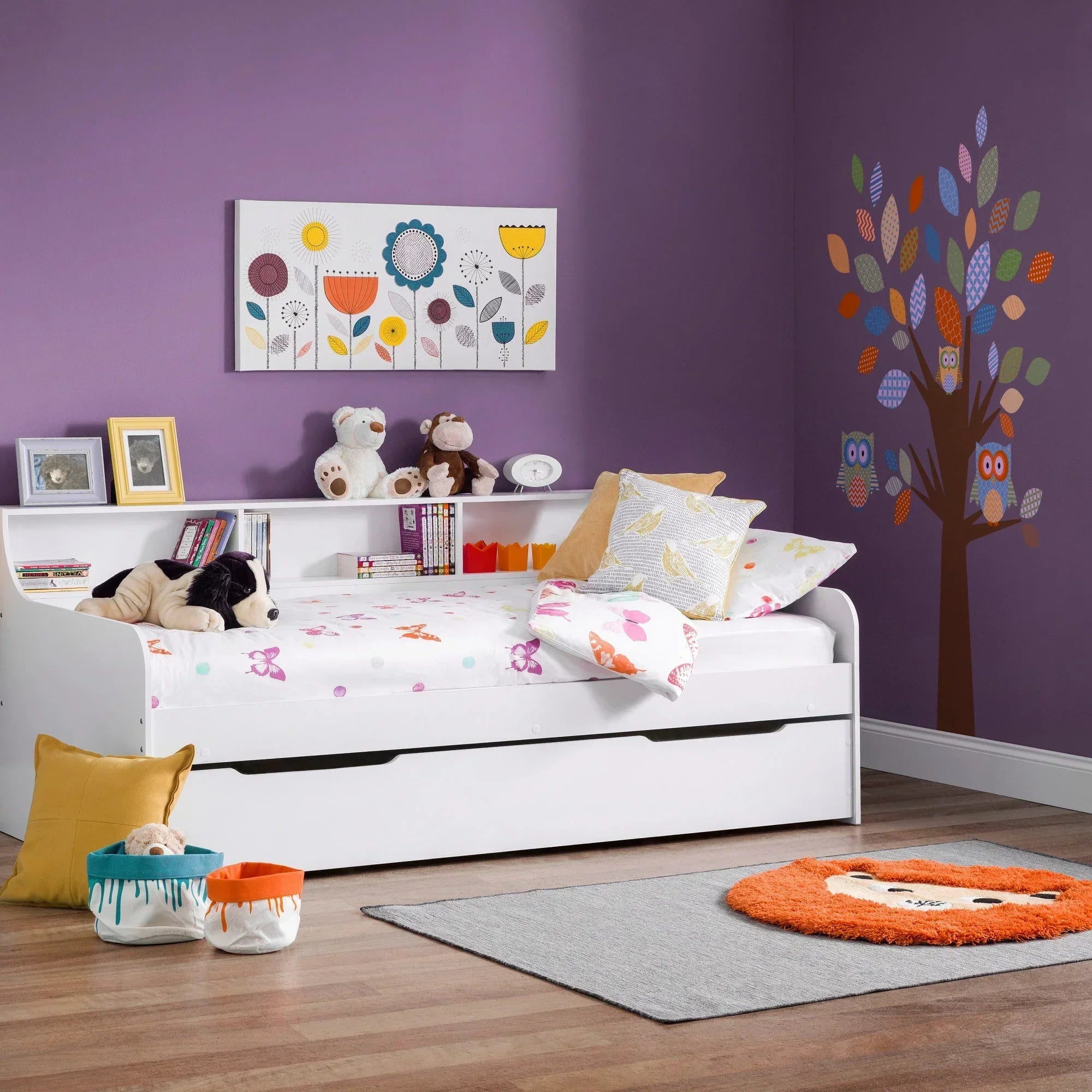 White kids bed with storage, shelves, and playful bedding in a purple themed bedroom
