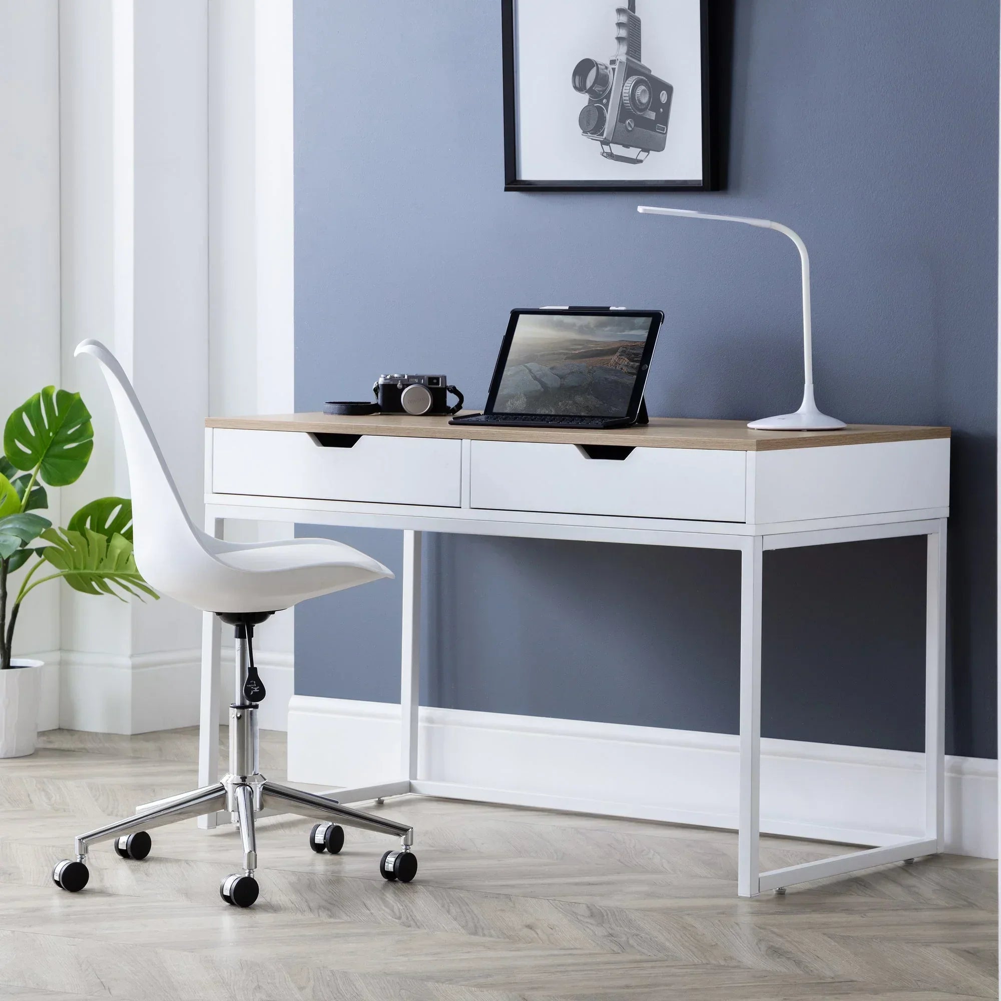 White ergonomic office chair with chrome base at modern desk in bright home office