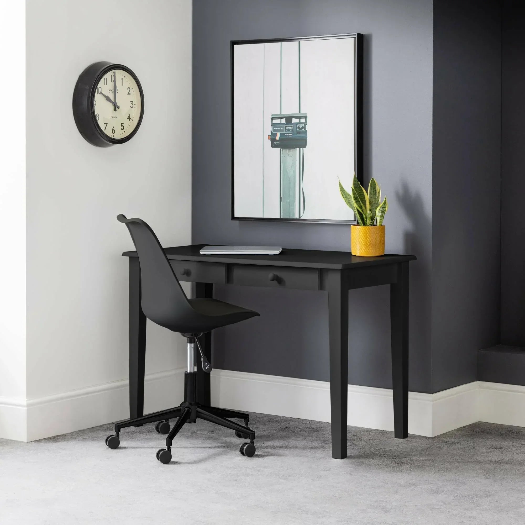 Black office chair with wheels at black desk in modern home workspace setting