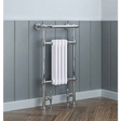 Chrome towel radiator with a white towel against a gray paneled wall.