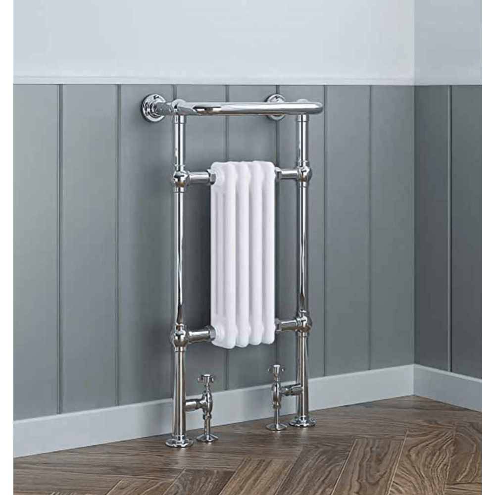 Chrome towel radiator with a white towel against a gray paneled wall.