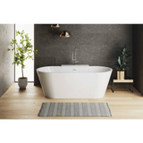 Modern bathroom with a freestanding bathtub, plants, and a gray wall.