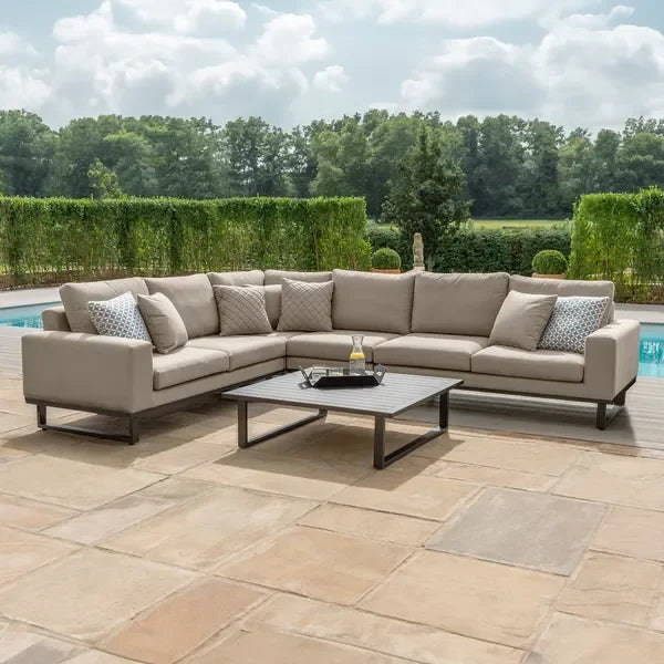 Large beige corner outdoor sofa set with cushions and coffee table on a patio