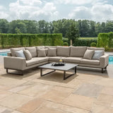 Large beige corner outdoor sofa set with cushions and coffee table on a patio