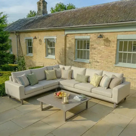 Latte corner group outdoor sofa set with cushions and coffee table on stone patio