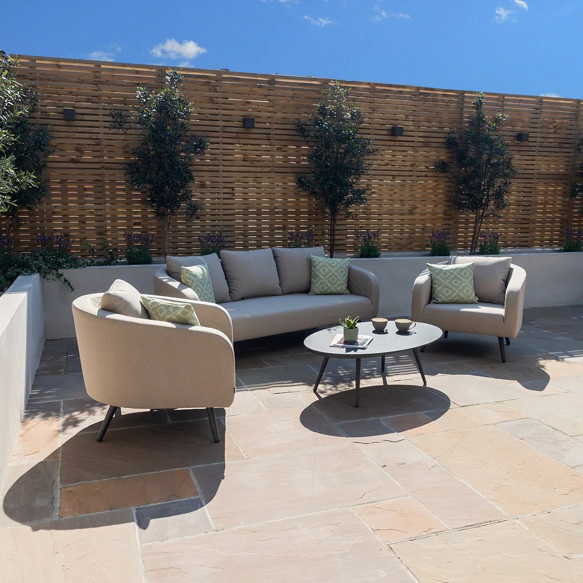 Outdoor beige fabric sofa set with armchairs and round coffee table on patio