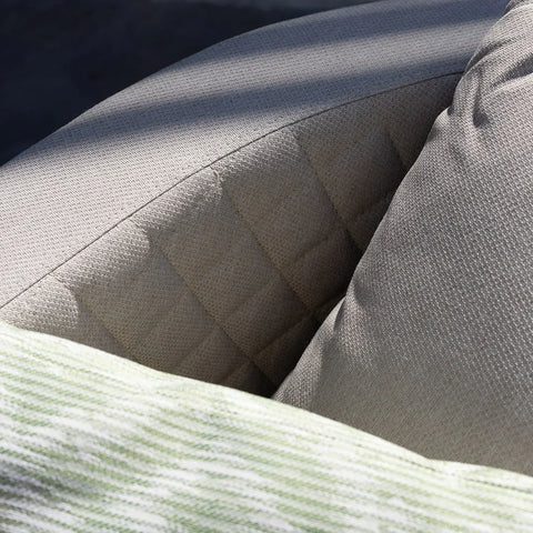 Beige outdoor sofa backrest with quilted detail and textured cushion close-up
