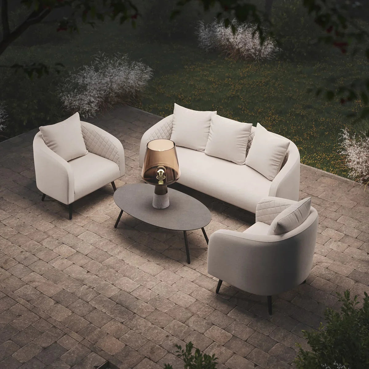 Cream outdoor sofa set with two armchairs, oval coffee table, and lamp on patio