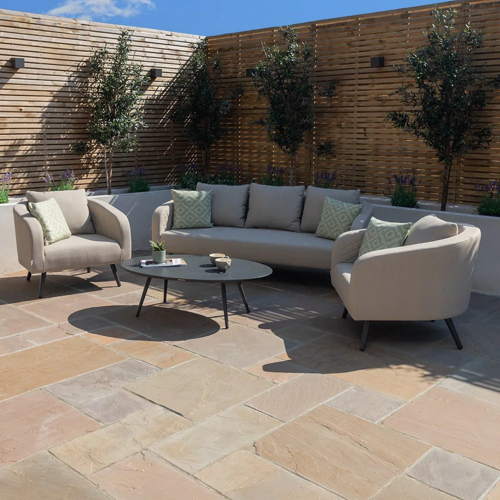 Outdoor patio furniture set with beige sofa, two armchairs, and black round coffee table