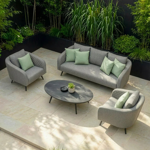 Grey outdoor sofa set with armchairs, light green cushions, and oval table on patio tiles