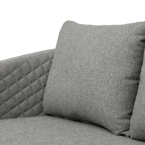 Grey fabric sofa with quilted arm detail and matching cushion close-up