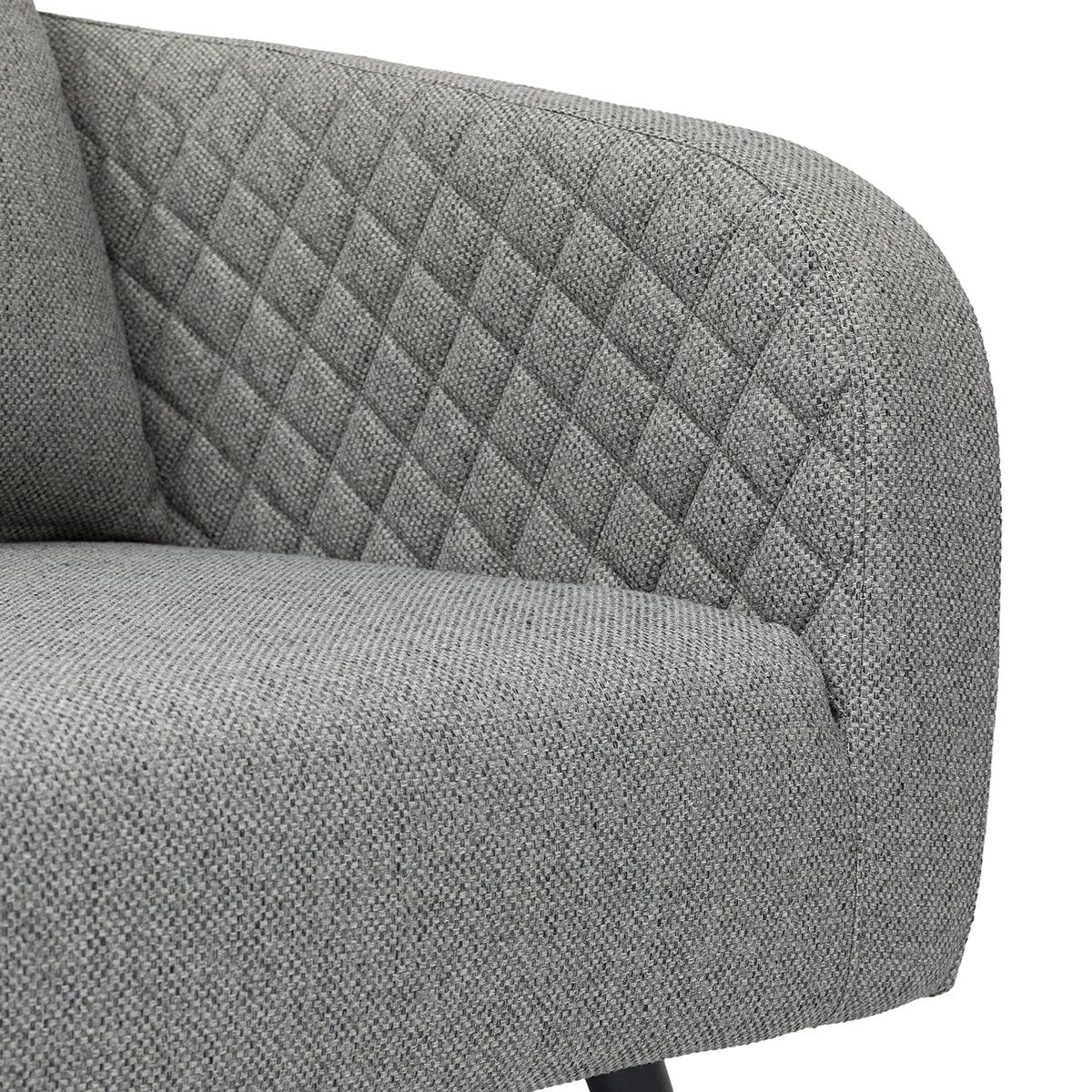 Grey fabric sofa with diamond quilted backrest and textured seat close-up