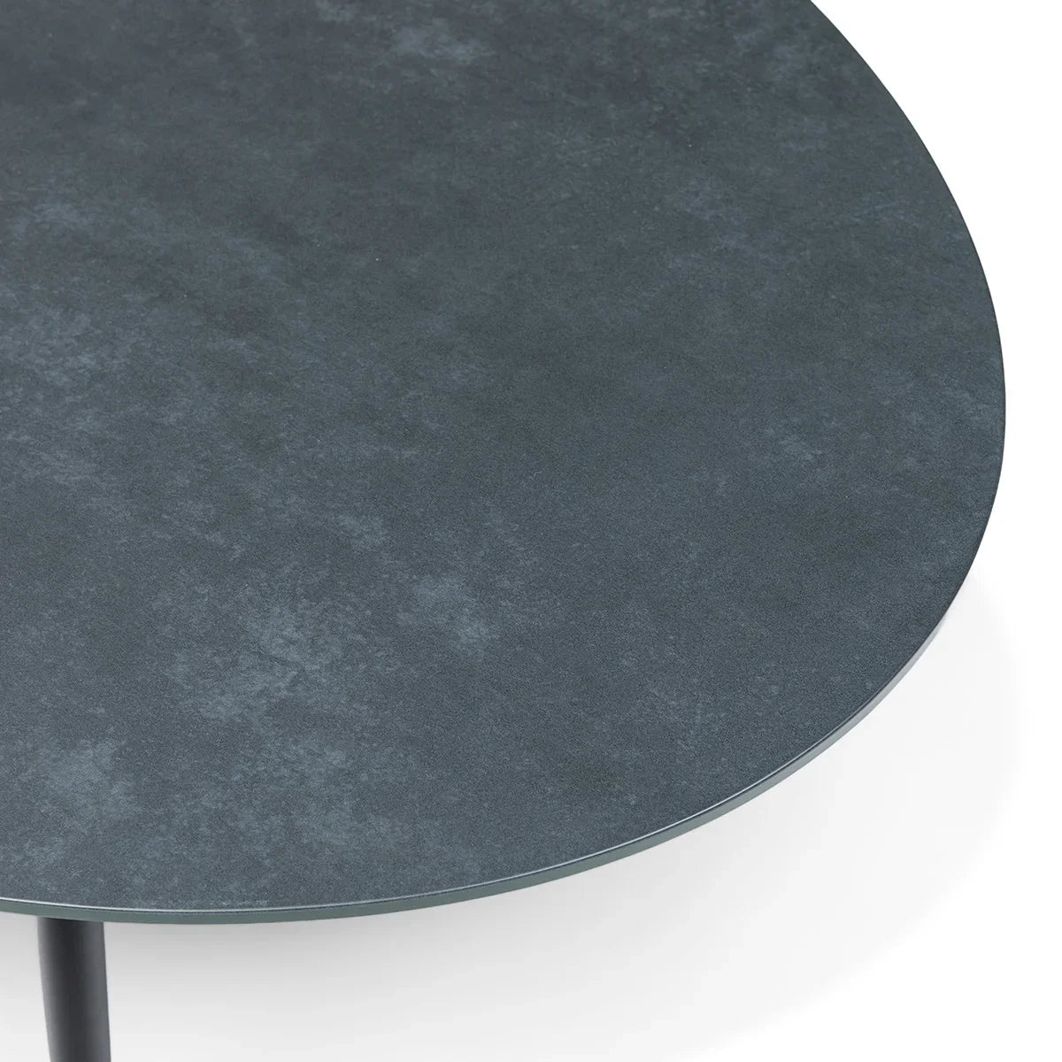 Close-up of round stone effect coffee table with dark textured tabletop